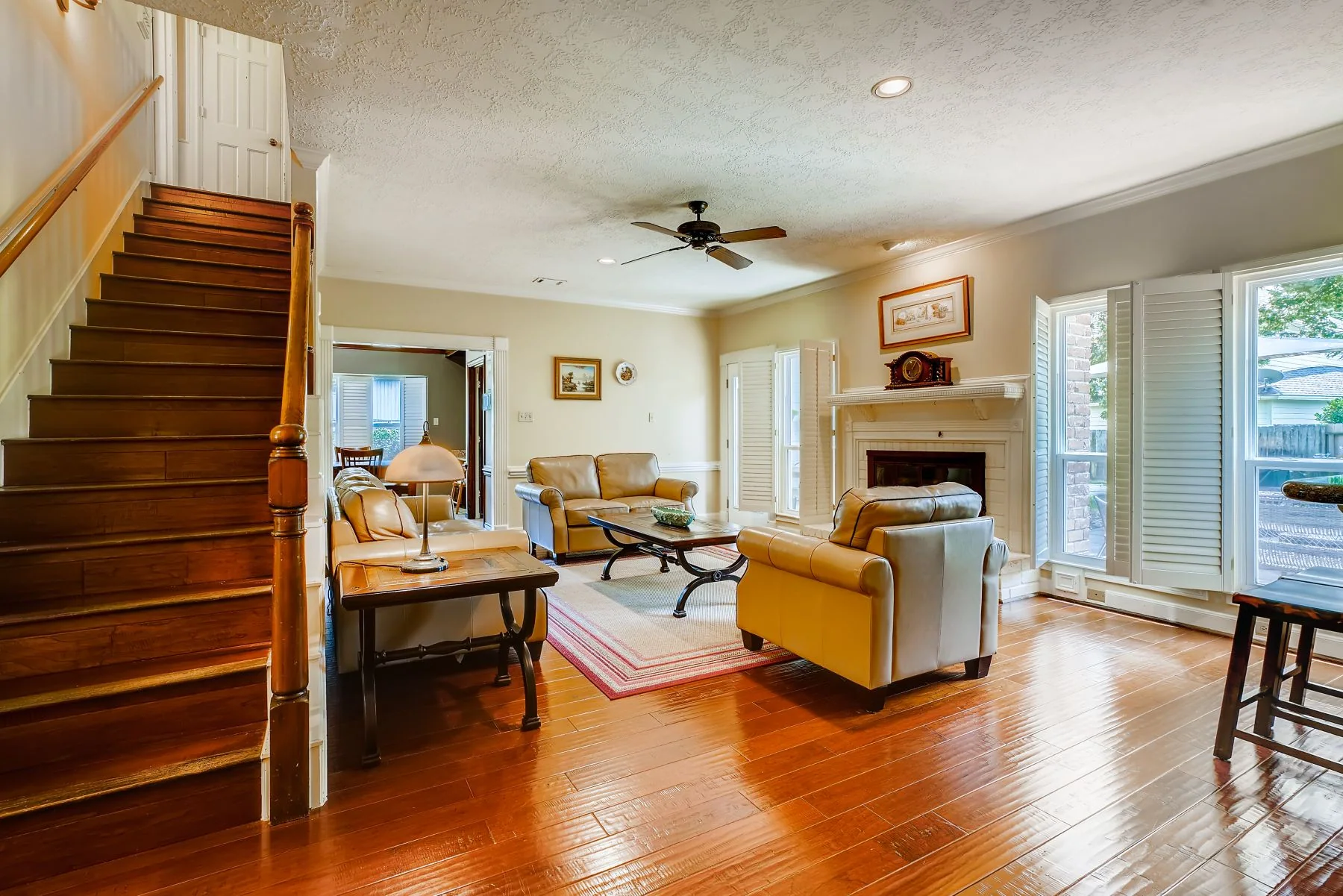 Warm wood-toned flooring extending across a bright living room